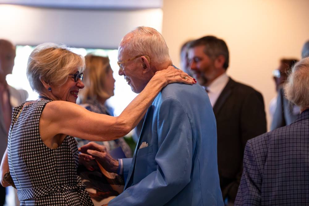 Two reception guests smiling at each other.